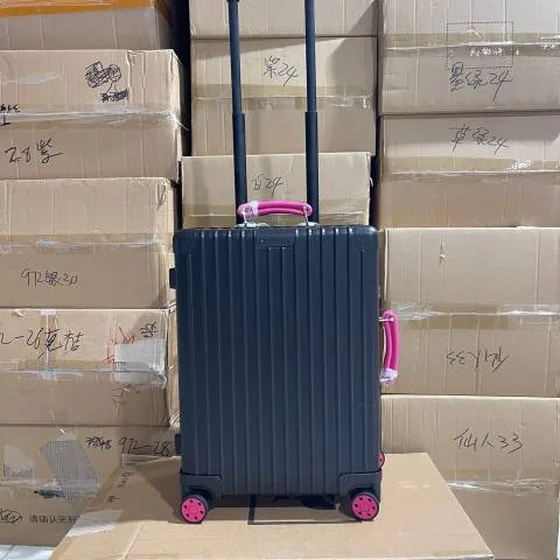 Rimowa suitcase สีดำ with สีชมพู handles travel