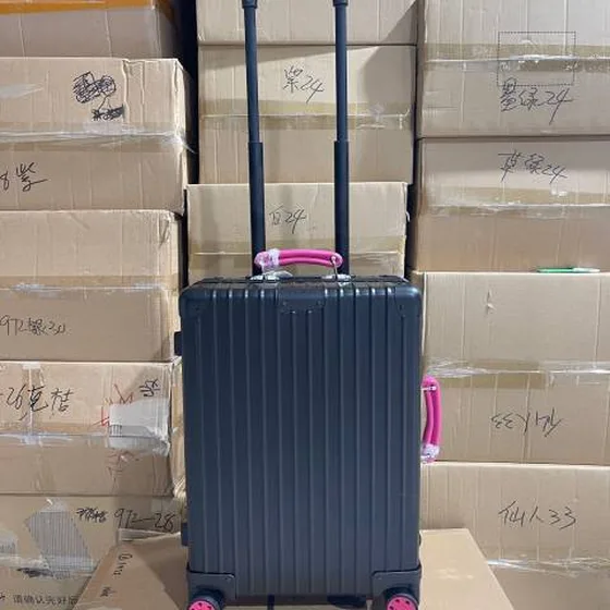 Rimowa suitcase สีดำ with สีชมพู handles travel